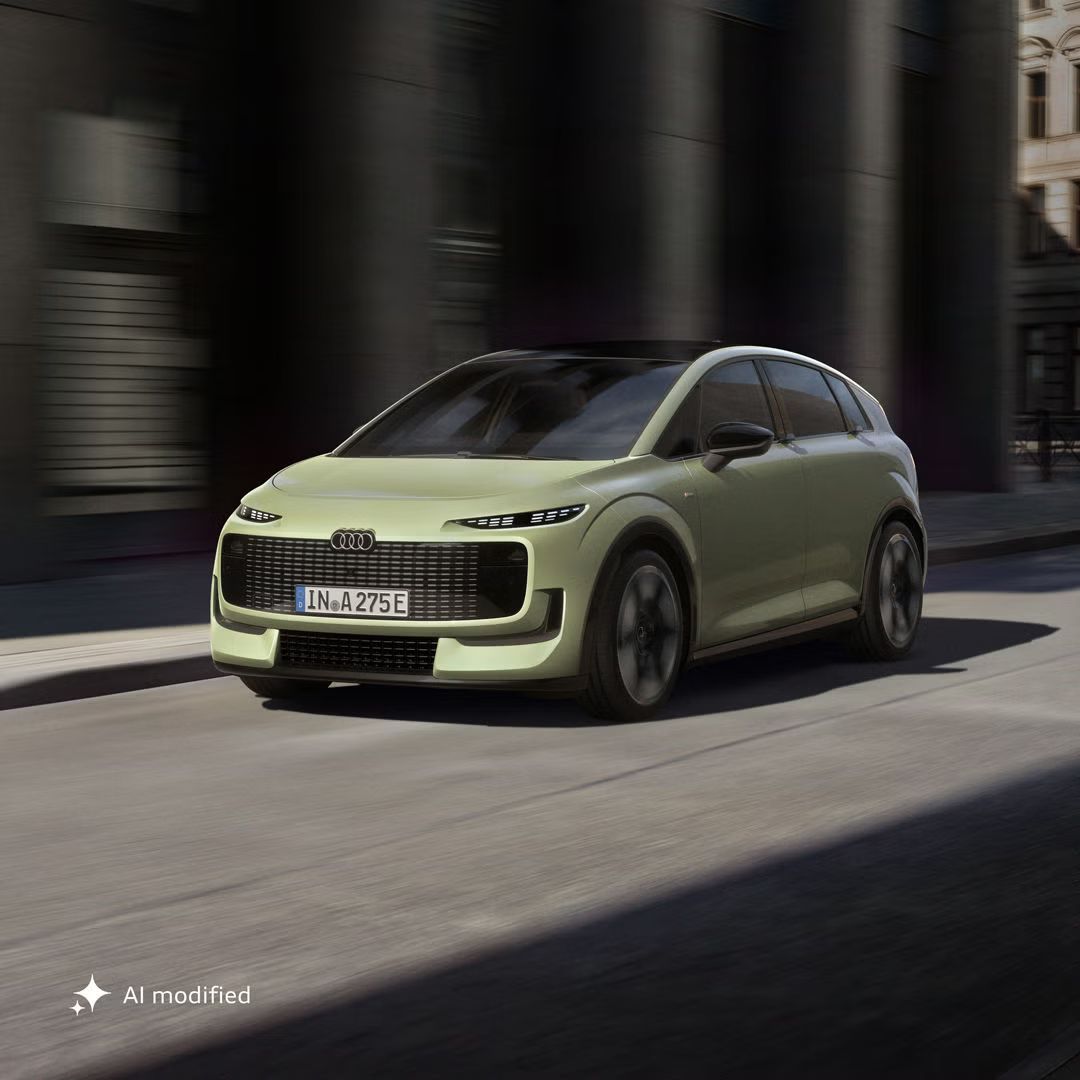 Audi A2 e-tron šikmo spredu, na úzkej ceste v mestskom prostredí.
