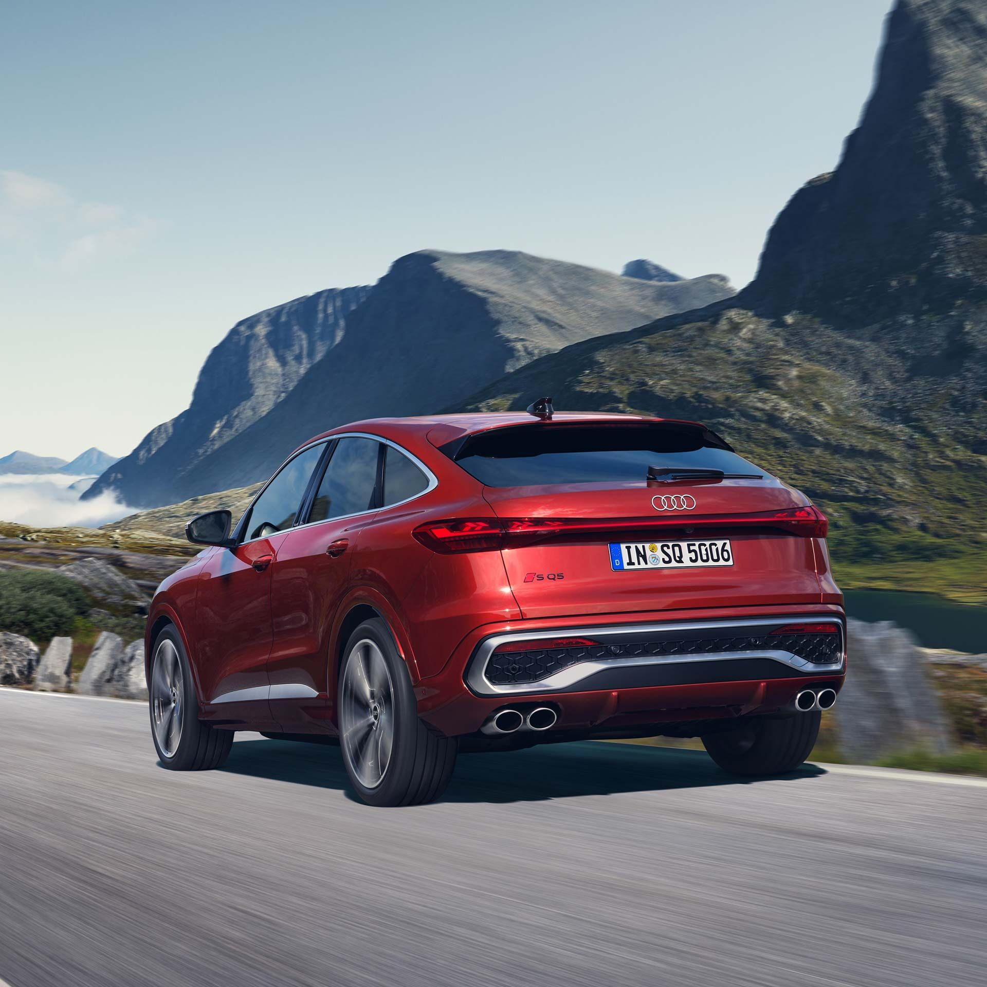 Audi SQ5 Sportback počas jazdy po ceste. Okolie tvoria impozantné hory.