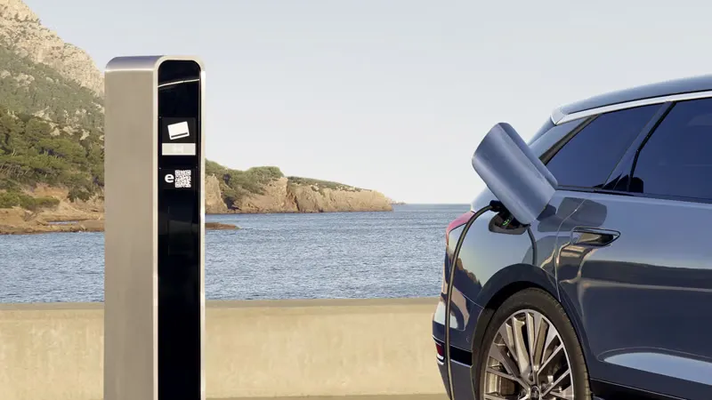 Audi  e-tron je pripojené k verejnej nabíjacej stanici na parkovisku na pobreží a nabíja sa.  