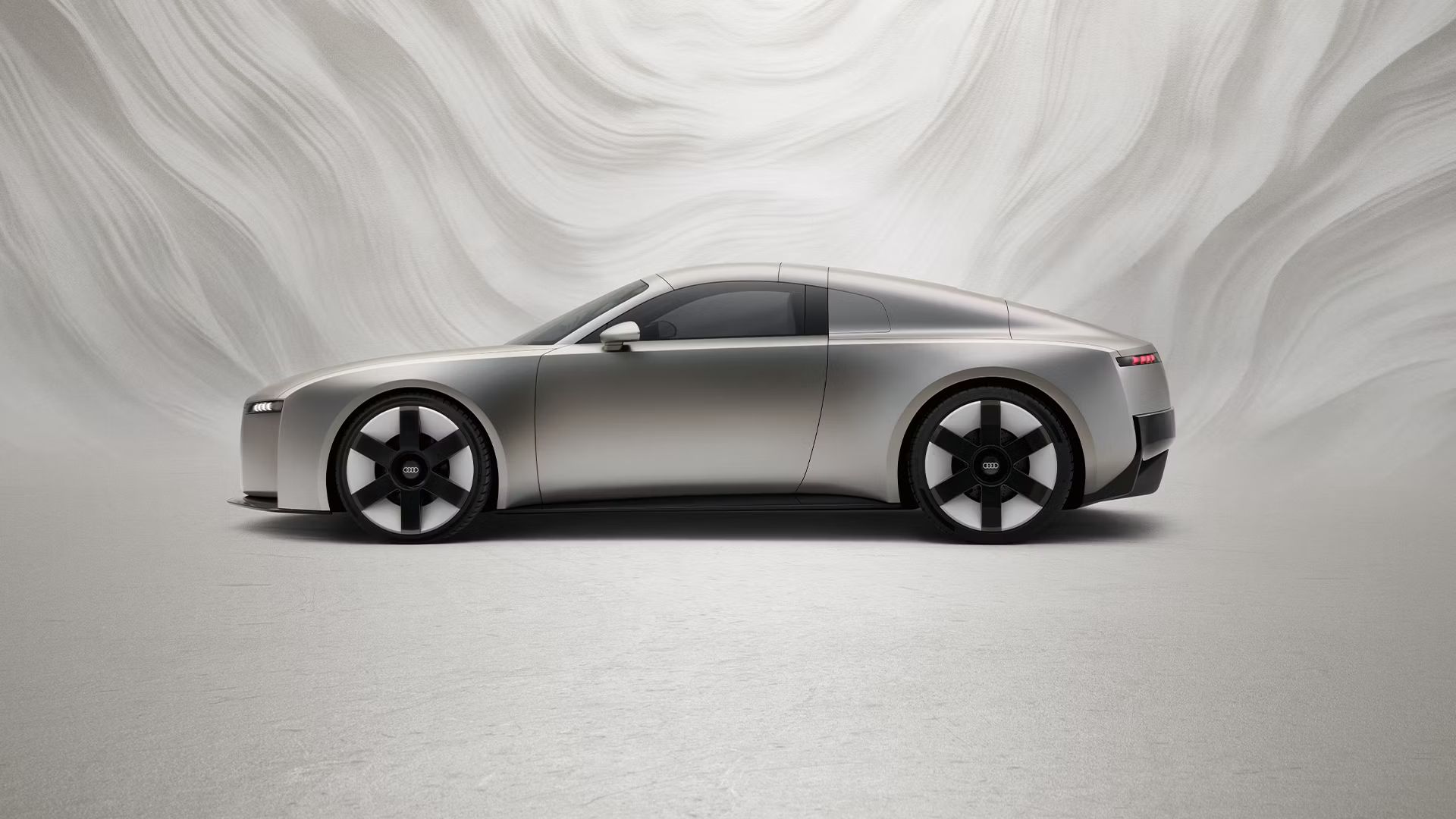 Bočný pohľad na Audi Concept C pred grafickým pozadím.