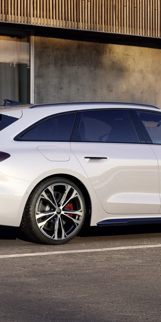 Biely Audi A5 Avant e-hybrid zaparkovaný vedľa nabíjacej stanice
