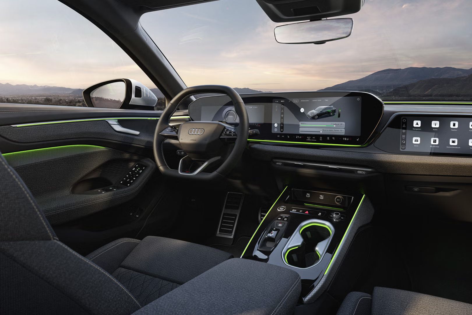 Pohľad na displeje a volant v kokpite modelu A6 Avant e-hybrid. Cez čelné sklo sú vidieť hory.