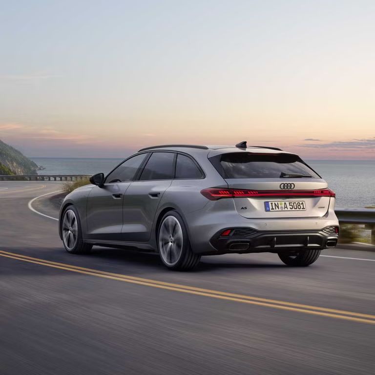 Pohľad na zadné partie Audi A5 Avant počas dynamickej jazdy po ceste popri pobreží.
