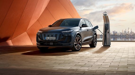 Seitliche Frontalansicht eines Audi SQ6 SUV e-tron neben einer Ladesäule
