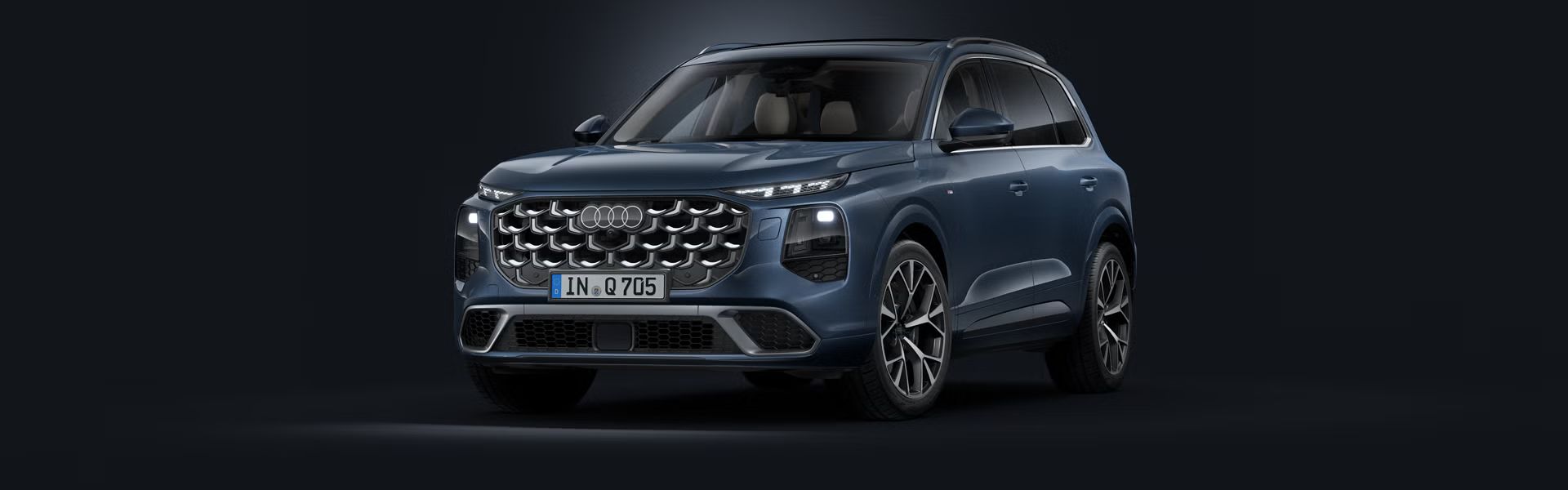 Šikmý pohľad spredu na SUV Audi Q7 na tmavom pozadí.