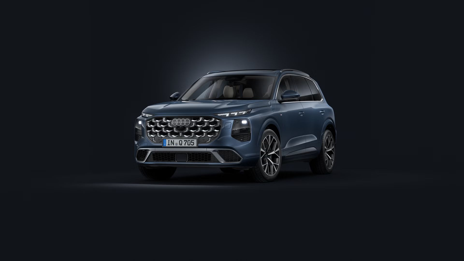 Šikmý pohľad spredu na SUV Audi Q7 na tmavom pozadí.