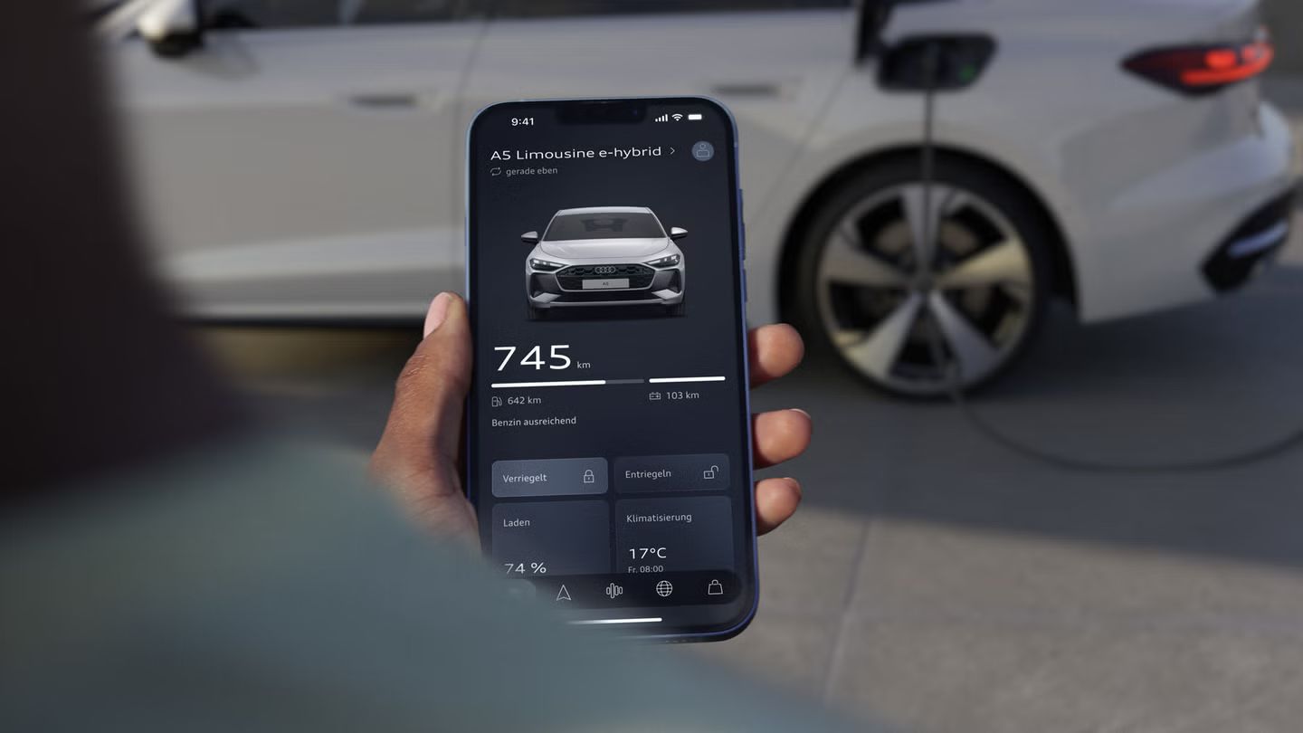 Osoba kontroluje stav nabitia batérie vozidla Audi A5 Limuzína e-hybrid na smartfóne. 
